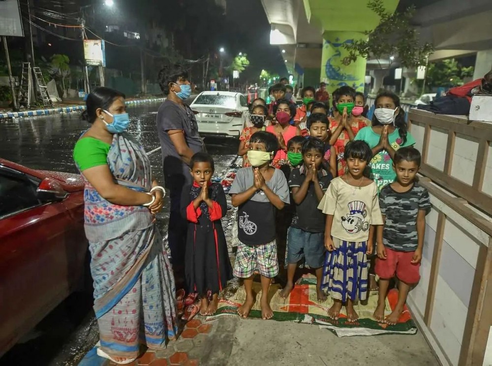 Underprivileged children offer prayers before attending a class at a pavement school in the evening, during Unlock 3.0, in Kolkata. (PTI Photo/Swapan Mahapatra)